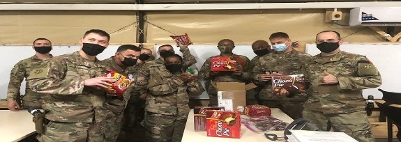 Soldiers in Afghanistan with the boxes of goodies from HHOOT's Distribution Center that Helping Heroes of America sent to them. 